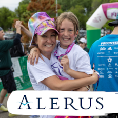 A GOTR participant shows offer her medal and proudly smiles while hugging her caregiver.